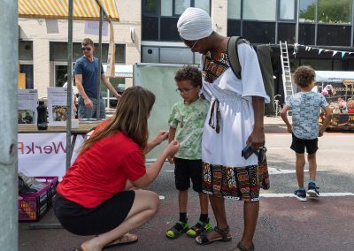Bezoekers genieten van de Multiculturele Markt Paddepoel 2026.